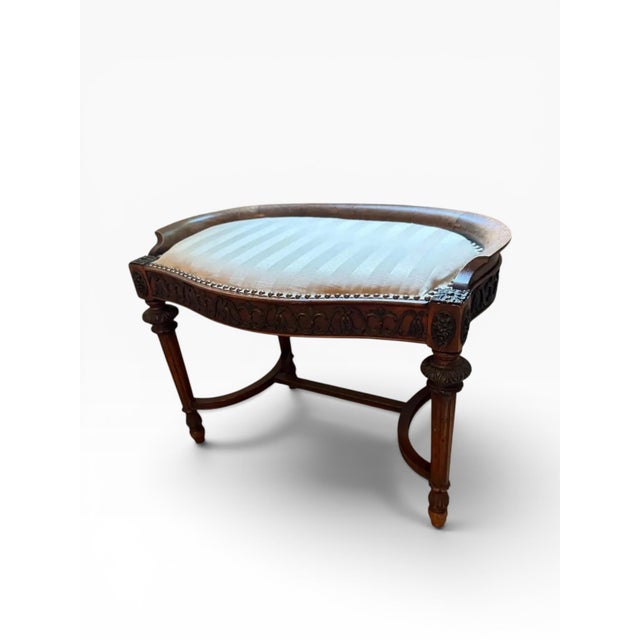 This antique Irish dressing table stool is a beautifully detailed piece, likely crafted in the early 20th century and...
