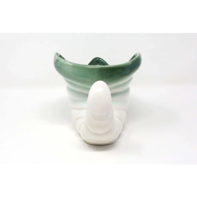 A vintage ceramic vase or planter by Regal Pottery, with a horn or cornucopia -shaped form, and green over white glaze....