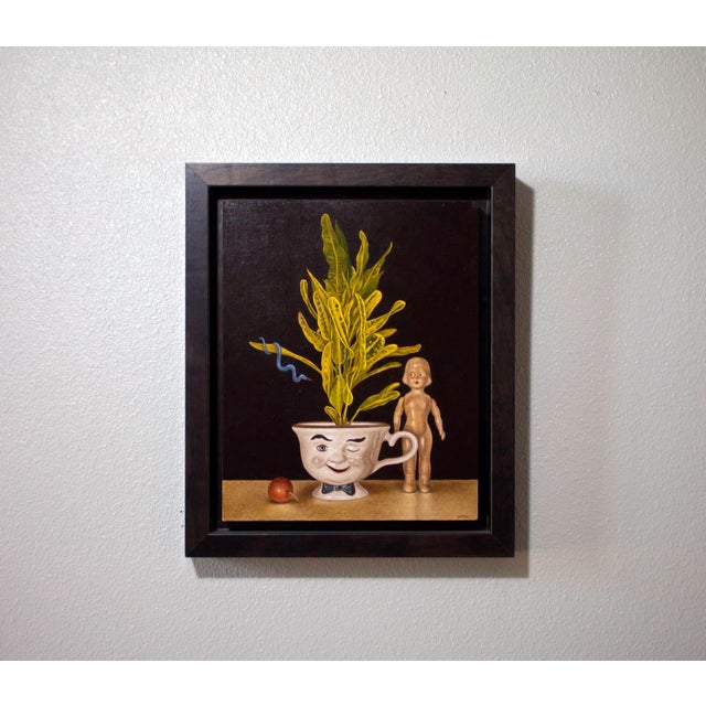 This oil on board artwork features a whimsical still life arrangement centered around a playful teacup with a mischievous...