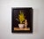 This oil on board artwork features a whimsical still life arrangement centered around a playful teacup with a mischievous...