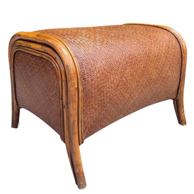 A vintage barrel form rattan ottoman featuring handwoven construction and a warm honey-toned finish. The sculptural...