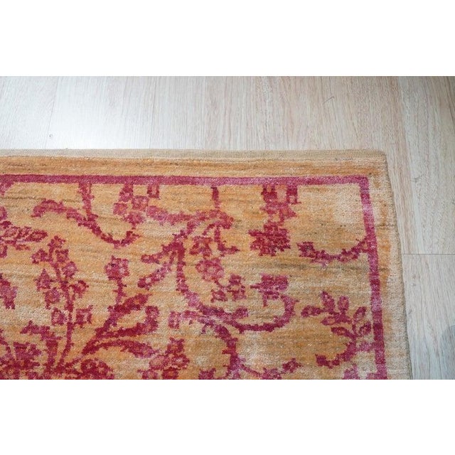 This hand knotted pile rug features a primary red and rust color palette and is crafted from wool. Designed in the classic...