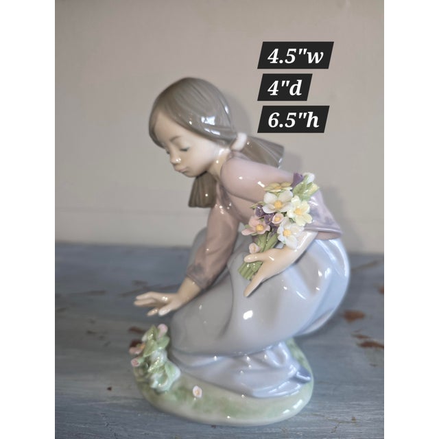 Pretty vintage Lladro figurine of a young girl gathering flowers.