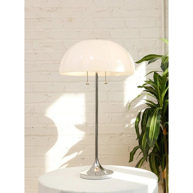 A striking vintage table lamp with a sculptural domed shade in glossy white, accented by a slender chrome stem and...