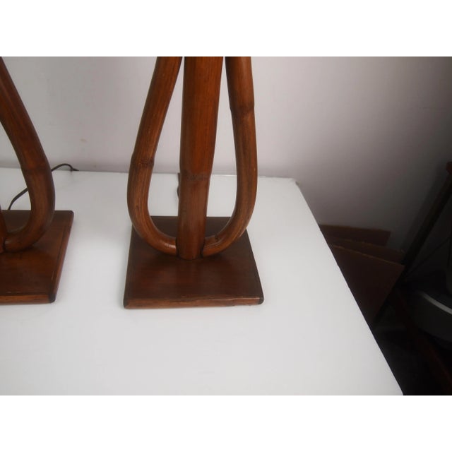 Pair of mid century bamboo or rattan lamps. Wired and in good working condition. Measures 18" to bottom of harp. 28" to...