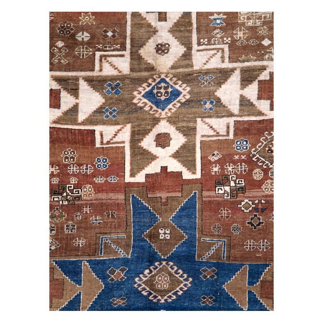 A vintage Caucasian Kazak accent rug with a geometric tribal design of 2 blue 8-point stars forming arrowheads and 1 cream...