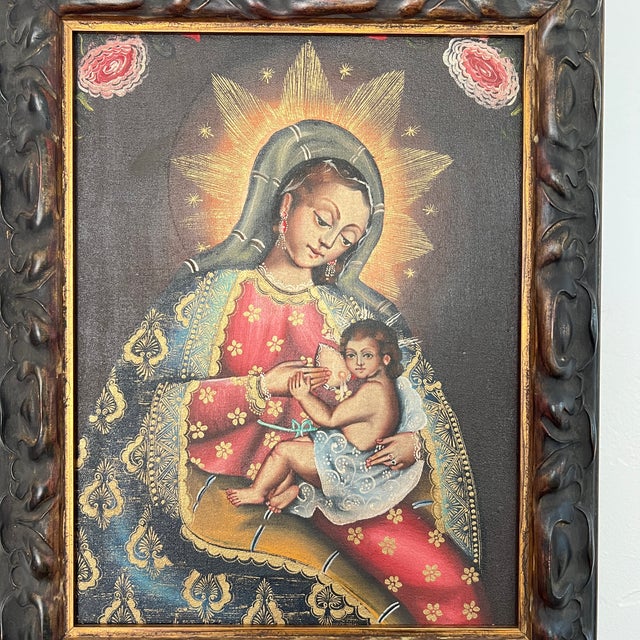 A painting of the Nursing Madonna in the style of the Cuzco School of religious art from Peru in a carved wood frame with...
