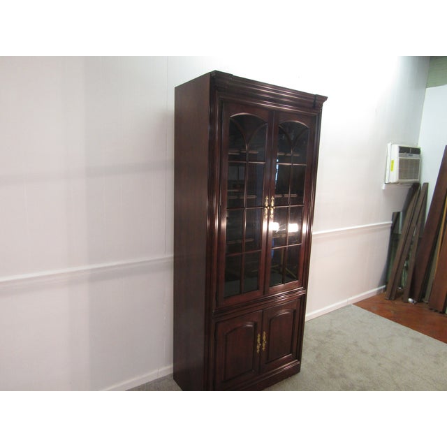 Item 87373: Statton solid cherry bookcase cabinet. Age: 1980's. Details: Glass shelves, a lighted interior and Old Towne...