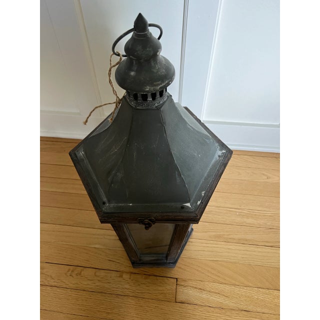 Aged look, farmhouse style lantern. Six glass panels, wood frame and zinc top with loop opens for candle or decorative...
