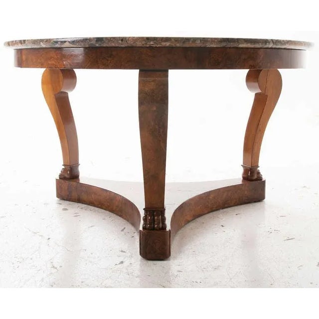 French Restauration period (19th century) center table made of burled walnut and cherry woods topped with a stunning disc...