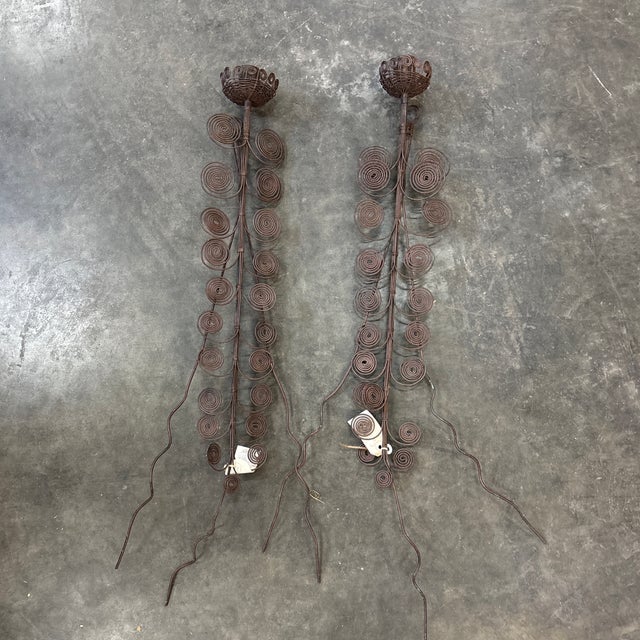 A pair of sculptural classic mid-20th Century modern style wall candlesticks. These tall wire-sculpted candlesticks would...