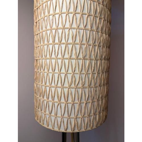 A captivating highlight of sculptural craftsmanship: this mid-century floor lamp with its woven raffia shade and chrome...