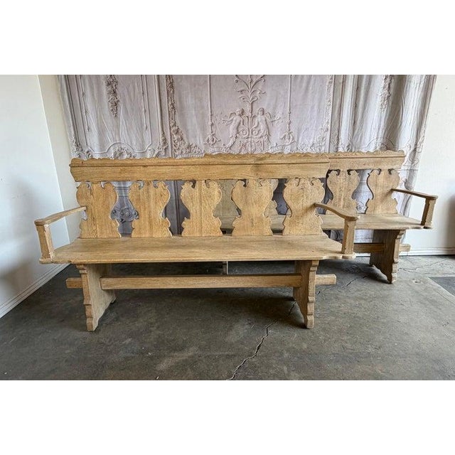 This striking pair of hand-carved wooden benches showcases a bold rustic character with sculptural silhouette details and...