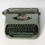 This Vintage Royalite Typewriter was manufactured in the 1950's with a grey-green base and forest green keys. The...