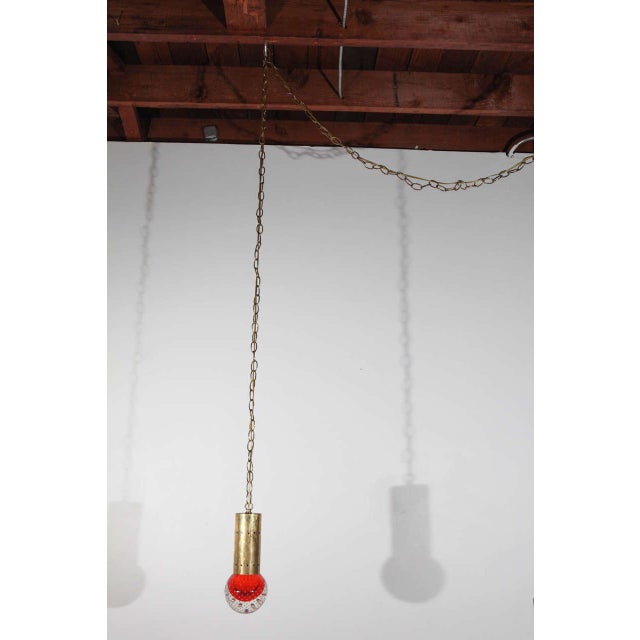 Pendant with blown glass sphere. Sphere contains controlled bubble inclusions. Fixture has a brass chain, and can be wired...
