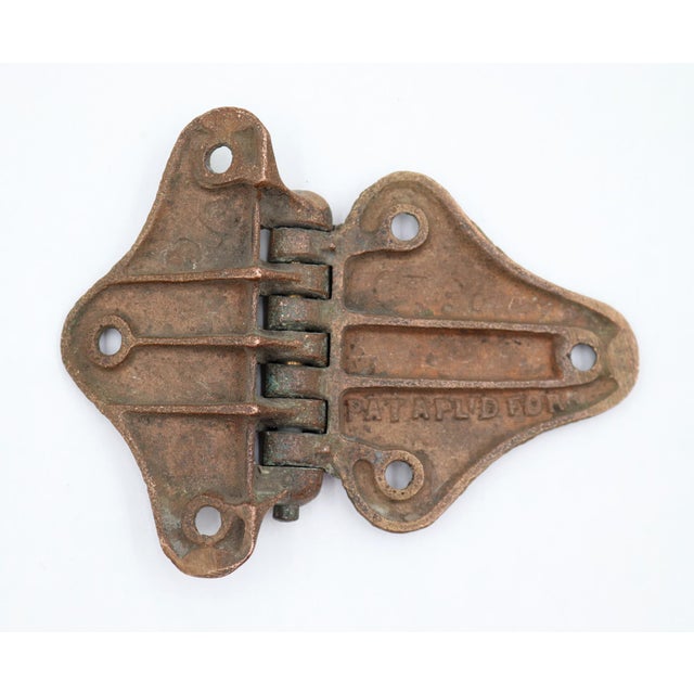 Antique butterfly ice box hinge made of bronze with a copper finish. The original mounting screws are not available. Good...