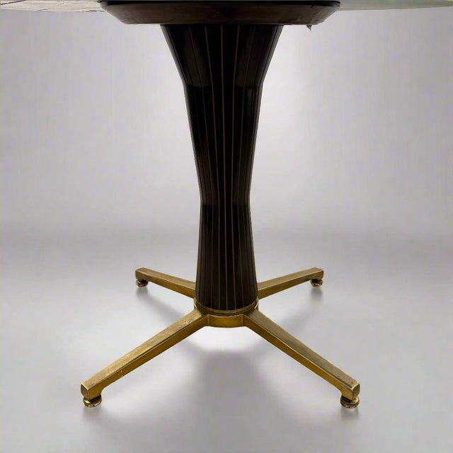 This elegant dining table features an hourglass shaped base of black hardwood with brass inlay. The top is a reverse...