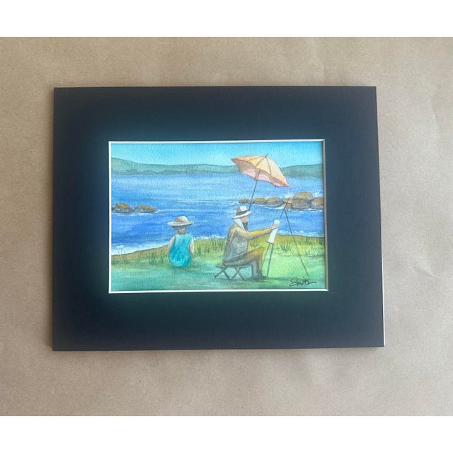 Capture the timeless charm of a peaceful day by the water with this original watercolor depicting an artist painting en...