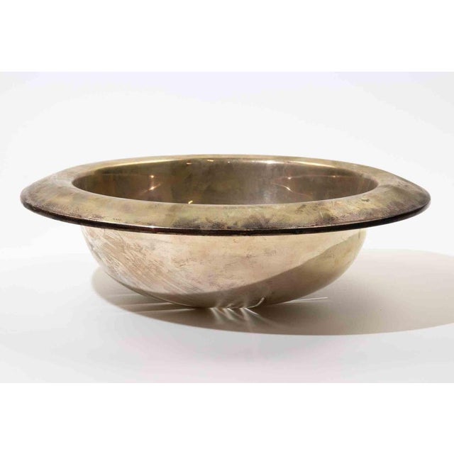 Striking modernist silver bowl featuring a broad rolled rim and sculptural hemispherical form. The minimalist design is...
