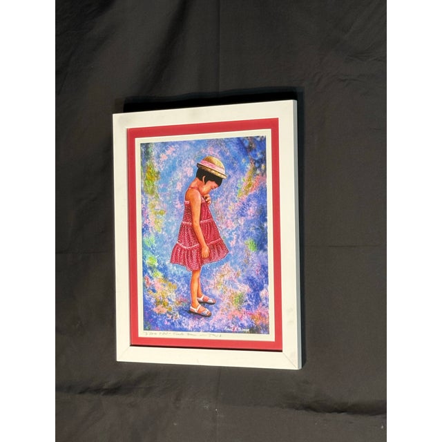 Decorative framed portrait print featuring a young girl in a red dress and hat against a colorful blue, purple, and...