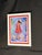 Decorative framed portrait print featuring a young girl in a red dress and hat against a colorful blue, purple, and...