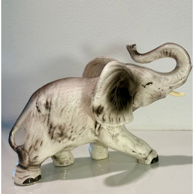Vintage ceramic elephant with a raised trunk (for good luck!) and hand painted gray and black shading. This folk art...