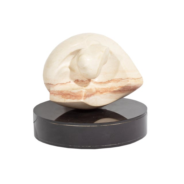 A stone sculpture by American artist Newell Hillis Arnold (1906-1988). This sculpture, in pink stone, comes in an...