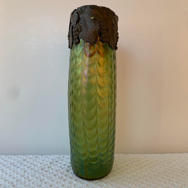 Antique Bohemian Green Iridescent Rippled Art Glass Vase with a Metal Collar in a grape leaf motif. The intricate design...