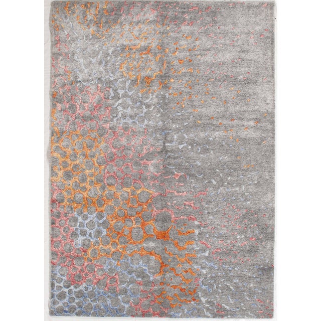 Hand-knotted modern rug featuring a dynamic abstract composition with organic, cell-like patterns flowing across a soft...