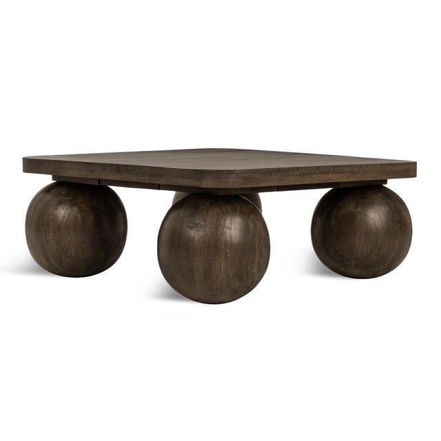 Modern square coffee table crafted from oak and mango wood with a rich walnut finish. The thick square top rests on bold...