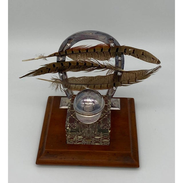 Antique English silver-plate desk set. Featuring an oak plinth, cut-glass inkwells with silver plate jockey hat lid, and a...