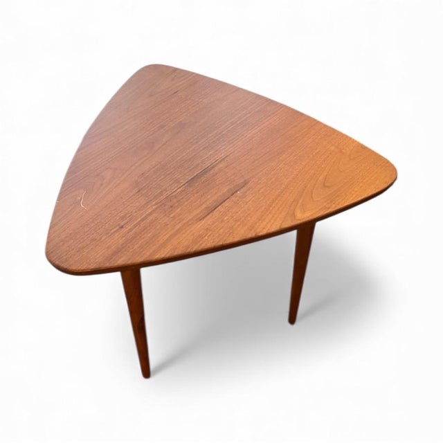 An authentic Jens Risom teak side table in the highly collectible “guitar pick” triangular form, a true Mid-Century Modern...