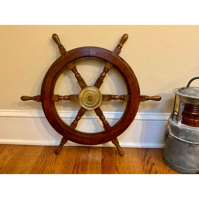 An authentic varnished mahogany six-spoke ship or yacht wheel with a solid brass hub and outer ring. Product Information:...
