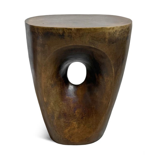 Organic modern antiqued brass finish aluminum stool or side table with hole cutout in middle of base. Artistic design and...