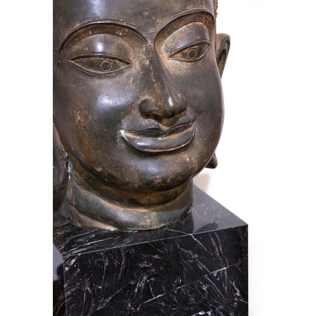 Beautiful ancient bronze head of Buddha, late 19th century. Good condition, it rests on a green marble base.