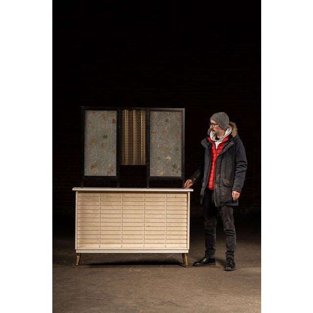Striking hybrid display piece combining a low, painted storage cabinet with an integrated decorative screen above. The...