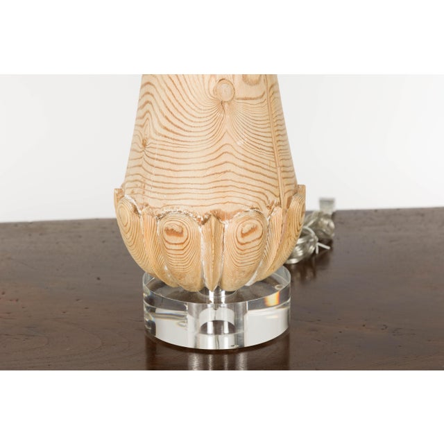 A pair of English Midcentury pine table lamps with natural finish, mounted on circular lucite bases. Illuminate your...