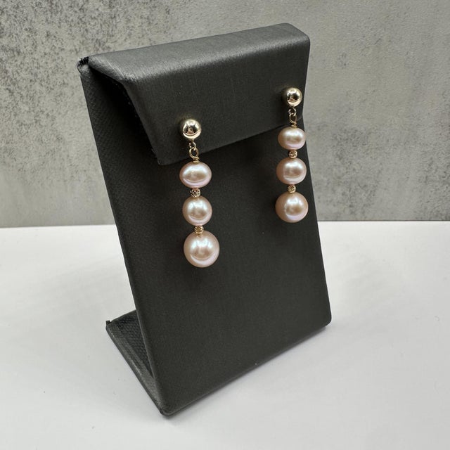 These beautiful pink pearl drop earrings in 14kt yellow gold feature six lustrous pink pearls in varying sizes, creating a...