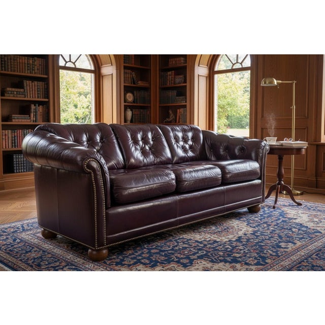 This striking vintage leather sofa beautifully captures the timeless sophistication of classic English Club design....