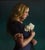 Katie by Sara Scribner | Oil on Aluminum Portrait of a woman holding white roses. For Sale