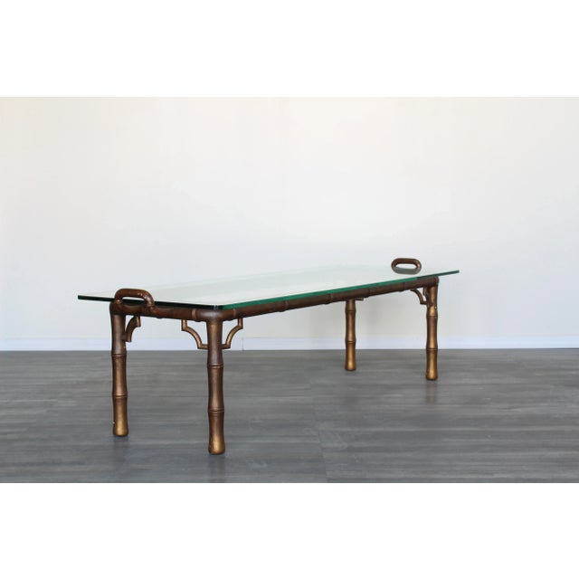 Vintage faux bamboo coffee table with glass top This is a solid wood table with faux pewter finish and glass top...