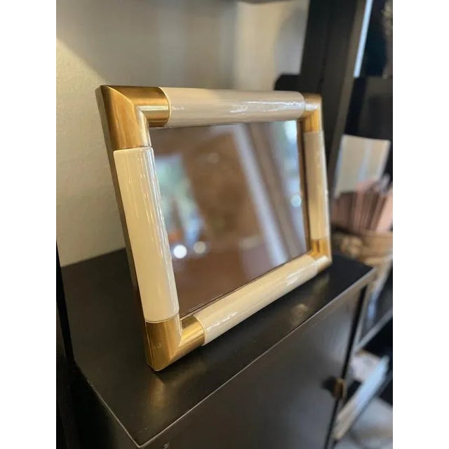 Photo frame with grey ceramic border and brass details. Crafted with a softly rounded grey ceramic frame, enriched by...