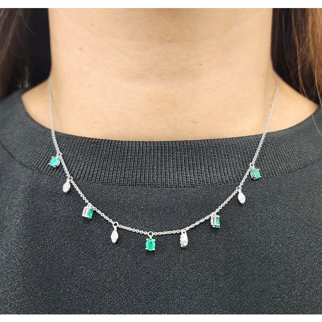 A modern necklace, exemplifying contemporary elegance. This piece features a series of oval-cut emeralds, totaling...
