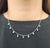 A modern necklace, exemplifying contemporary elegance. This piece features a series of oval-cut emeralds, totaling...