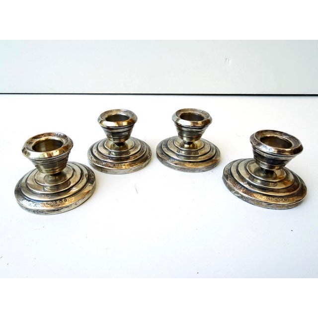 Elegant set of four antique English sterling silver candlesticks with a classic stepped base and understated traditional...