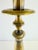 A vintage table lamp featuring a sculptural candlestick-form metal base with a warm antique brass finish and contrasting...