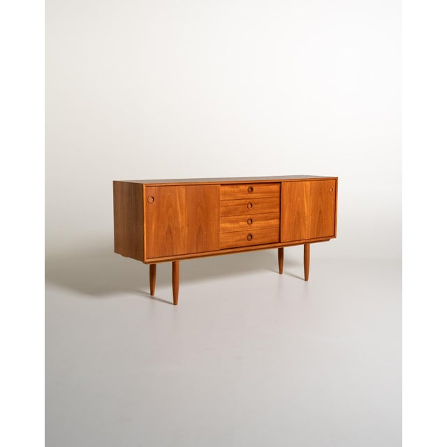 Danish-made teak sideboard from the 1960s, with two sliding doors and four central drawers. Original "made in denmark"...