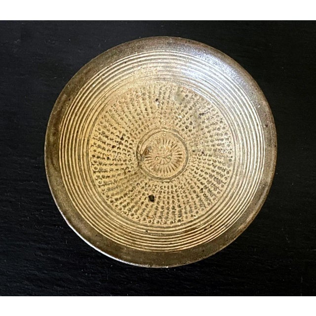 A small Korean ceramic shallow bowl on ringed foot in the classic Buncheong (or Punch'ong) style from Joseon Dynasty circa...