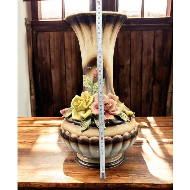 This vase, featuring three-dimensional relief flowers and a delicate hand-painted decoration, is an authentic example of...