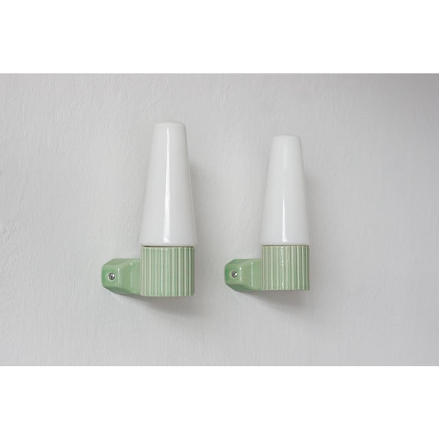 A pair of ceramic wall sconces designed by Hans-Agne Jakobsson for the Swedish company Ifö, representing a style...